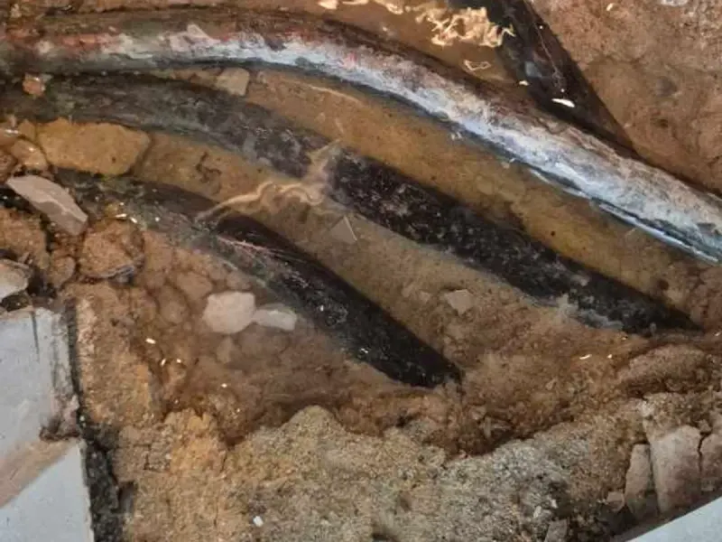 Wet pipes exposed in the screed where the leak was found