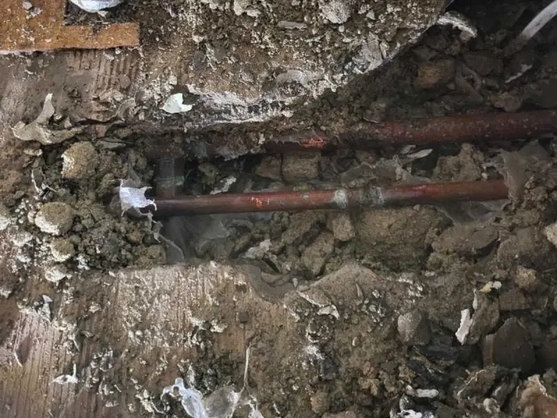 The exposed copper hot water pipe in the kitchen screed where the leak was located